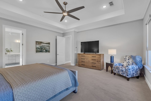 carpeted bedroom with connected bathroom, a raised ceiling, and ceiling fan