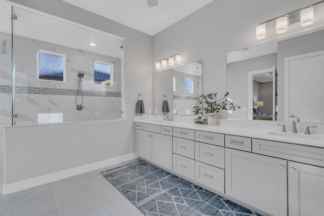 bathroom with vanity, tile patterned flooring, and tiled shower