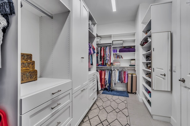 walk in closet with light tile patterned floors