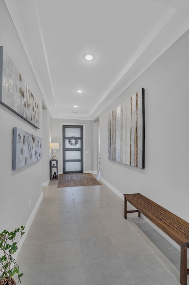 corridor featuring a tray ceiling and light tile patterned flooring