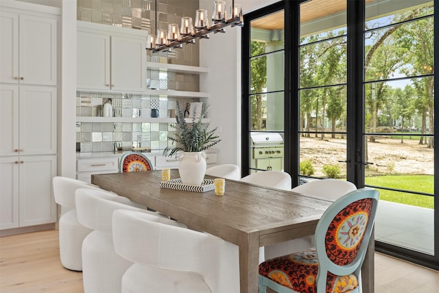 dining area with an inviting chandelier and light wood-type flooring