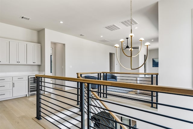 interior space with wine cooler, light hardwood / wood-style flooring, and a chandelier