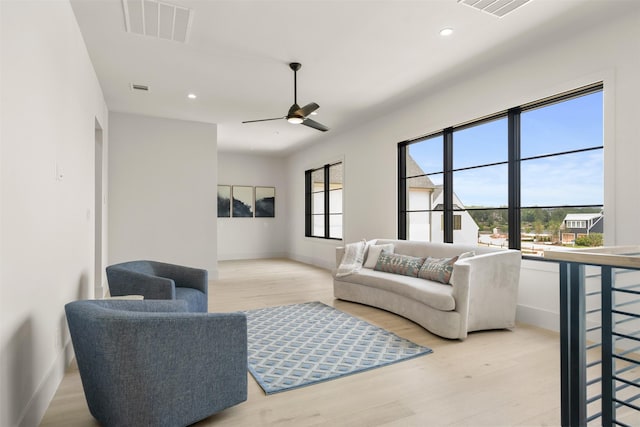 living room with light hardwood / wood-style flooring, a wealth of natural light, and ceiling fan