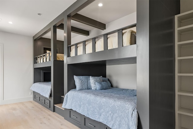 bedroom with beam ceiling and light hardwood / wood-style flooring