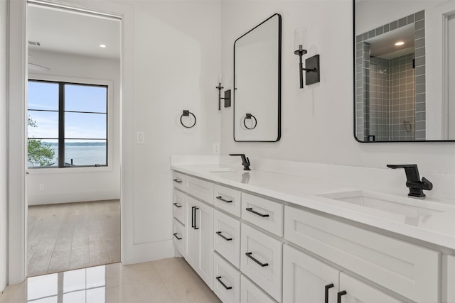 bathroom with a water view, vanity, and wood-type flooring