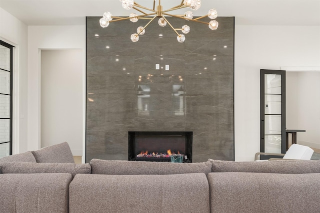 living room featuring an inviting chandelier and a high end fireplace