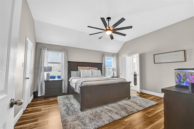 bedroom with multiple windows, wood-type flooring, vaulted ceiling, and ceiling fan