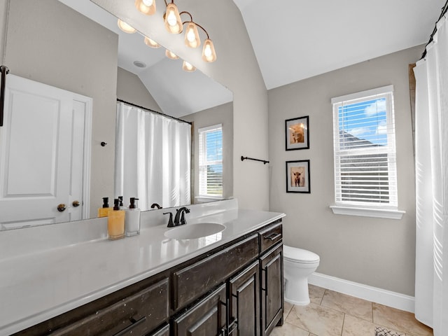 bathroom featuring tile patterned flooring, vaulted ceiling, vanity, and toilet