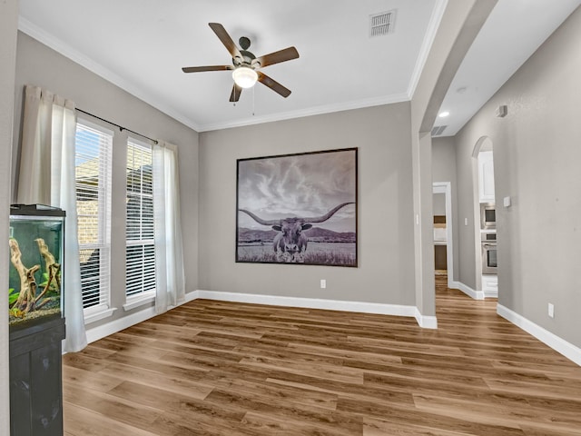 spare room featuring hardwood / wood-style floors, crown molding, and ceiling fan