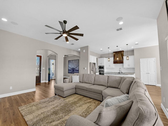 living room featuring dark hardwood / wood-style flooring, sink, and ceiling fan