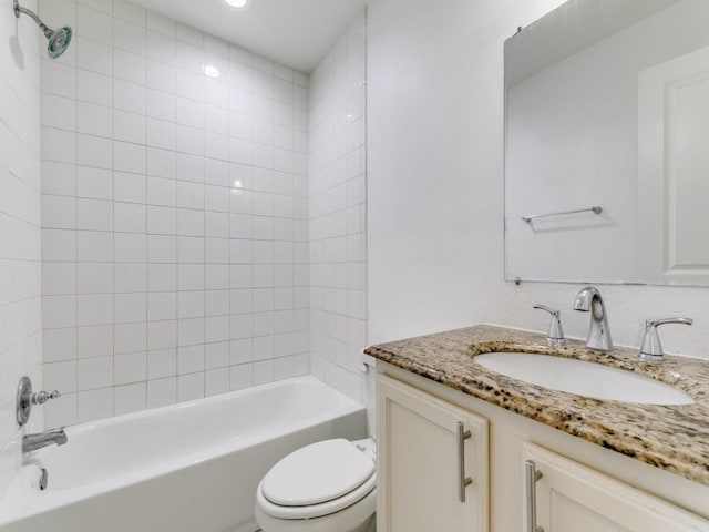 full bathroom with tiled shower / bath, vanity, and toilet