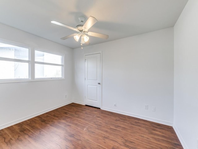 empty room with ceiling fan and dark hardwood / wood-style floors