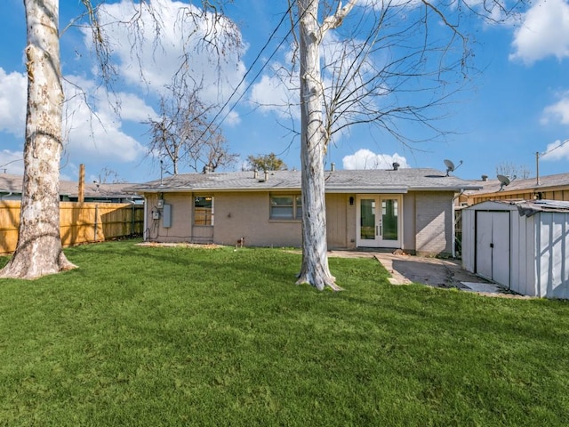 back of property with a storage shed, a lawn, and french doors