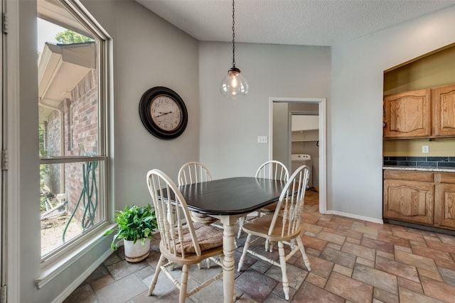 dining space featuring washer / clothes dryer and a textured ceiling