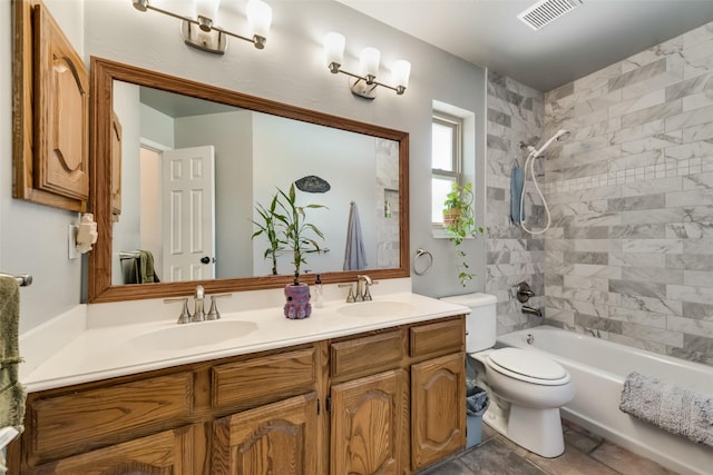 full bathroom with tiled shower / bath, vanity, and toilet