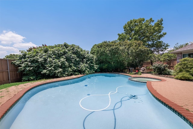 view of swimming pool featuring an in ground hot tub