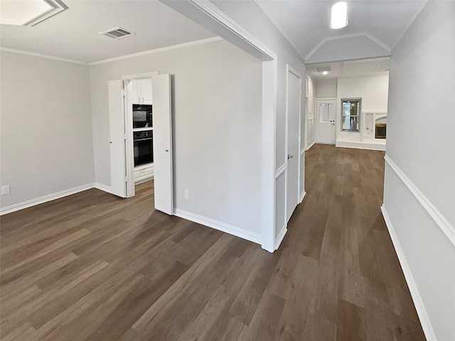 hallway featuring vaulted ceiling, dark wood-type flooring, and crown molding