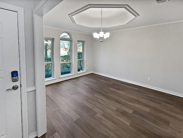 unfurnished dining area featuring an inviting chandelier, ornamental molding, dark hardwood / wood-style floors, and a raised ceiling