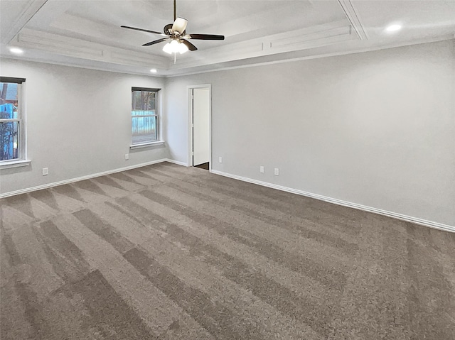 spare room with ornamental molding, carpet, ceiling fan, and a tray ceiling