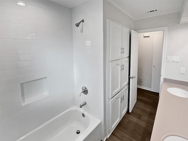 bathroom featuring vanity, hardwood / wood-style floors, and tiled shower / bath combo