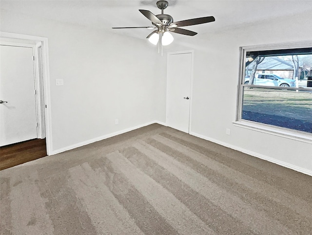 carpeted spare room featuring ceiling fan