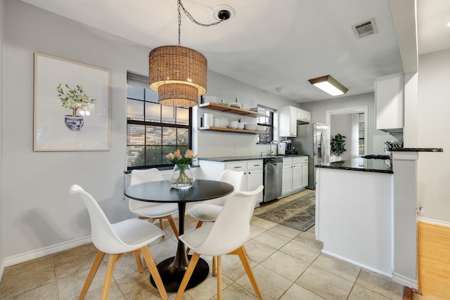 tiled dining room with sink and a notable chandelier