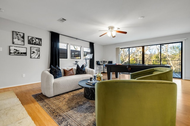 living room with ceiling fan, a wealth of natural light, and light wood-type flooring