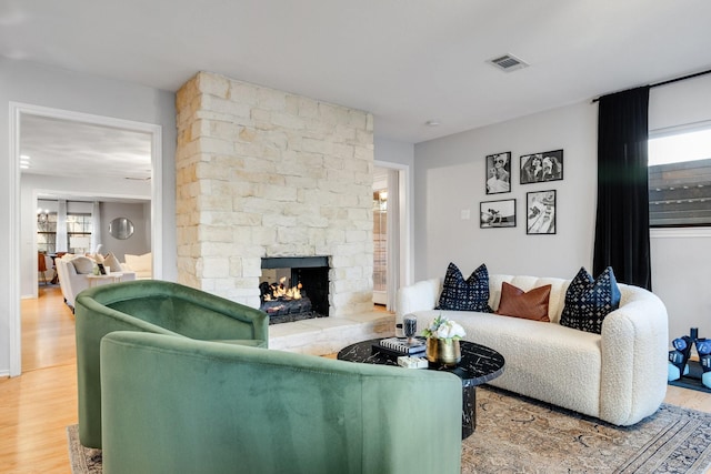 living room featuring hardwood / wood-style floors, a fireplace, and a healthy amount of sunlight