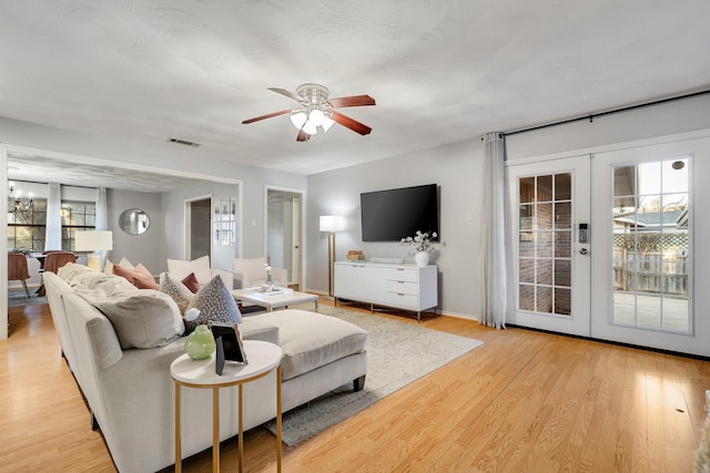 living room featuring light hardwood / wood-style flooring, ceiling fan, and french doors