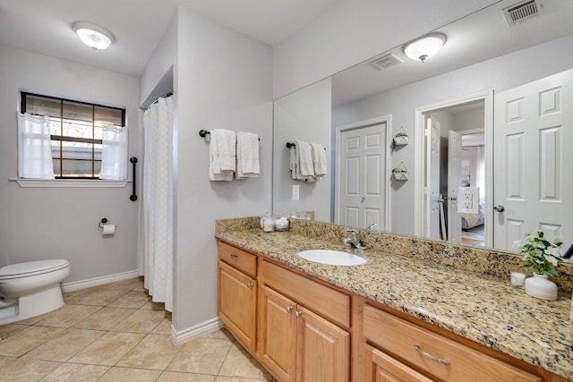 bathroom featuring vanity, tile patterned floors, and toilet