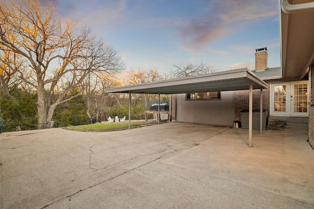 parking at dusk featuring a carport