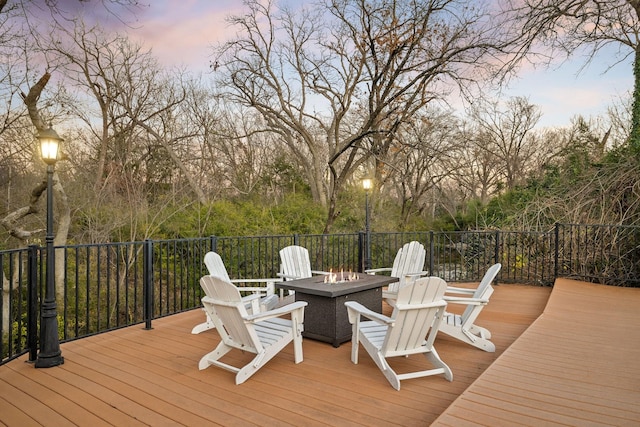 deck at dusk featuring an outdoor fire pit