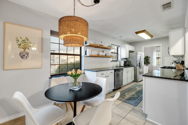 kitchen with white cabinetry, pendant lighting, stainless steel appliances, and a wealth of natural light