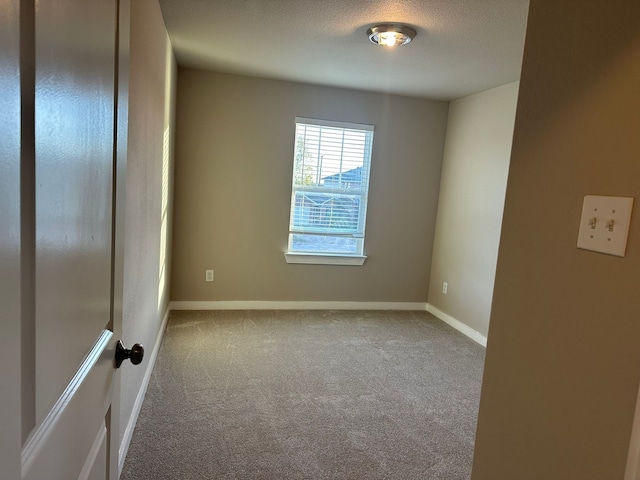 carpeted spare room featuring a textured ceiling