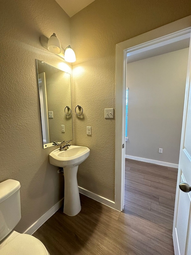 bathroom featuring sink, wood-type flooring, and toilet