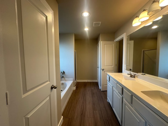 bathroom with independent shower and bath, wood-type flooring, and vanity