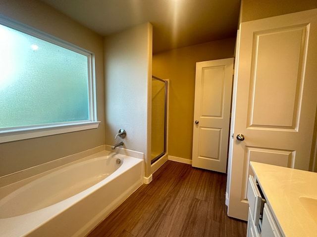 bathroom featuring vanity, separate shower and tub, and hardwood / wood-style floors