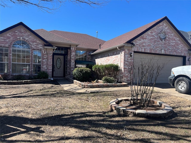 view of front of house featuring a garage, brick siding, driveway, and roof with shingles