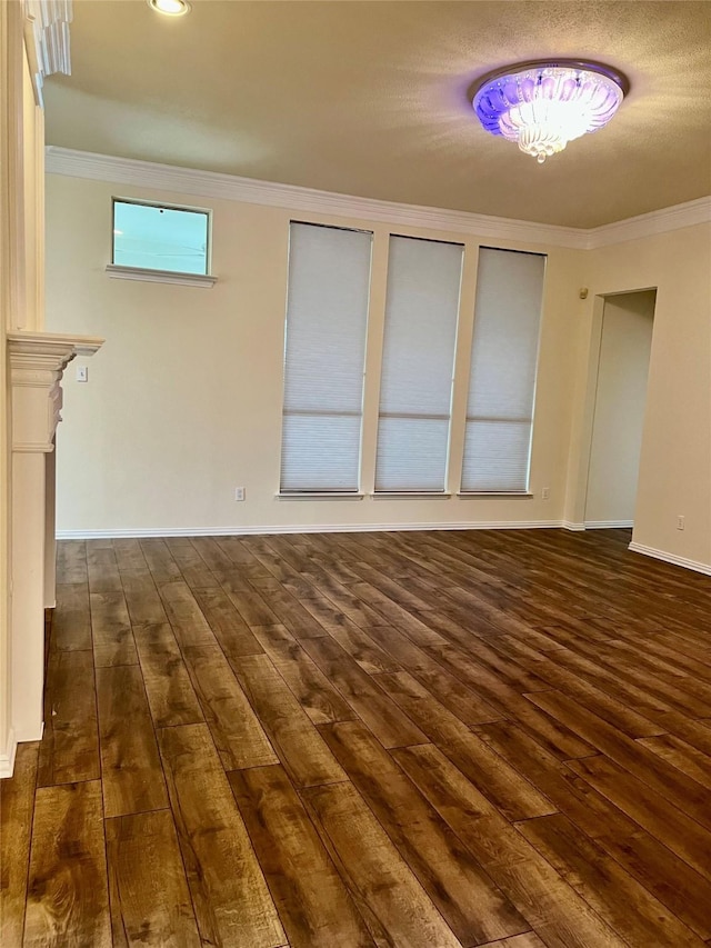 unfurnished living room featuring baseboards, ornamental molding, and dark wood finished floors