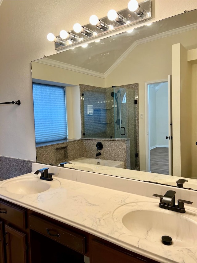 full bath with crown molding, double vanity, a sink, and a shower stall