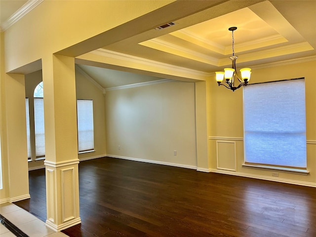 interior space featuring an inviting chandelier, crown molding, a raised ceiling, and wood finished floors