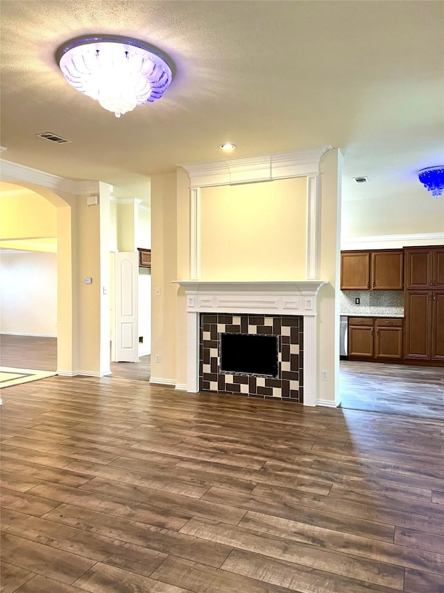 unfurnished living room featuring dark wood-style floors, visible vents, a fireplace, and baseboards