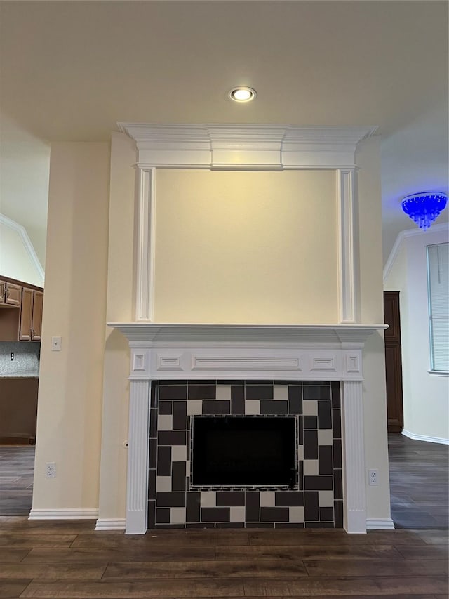 room details with ornamental molding, a fireplace, baseboards, and wood finished floors