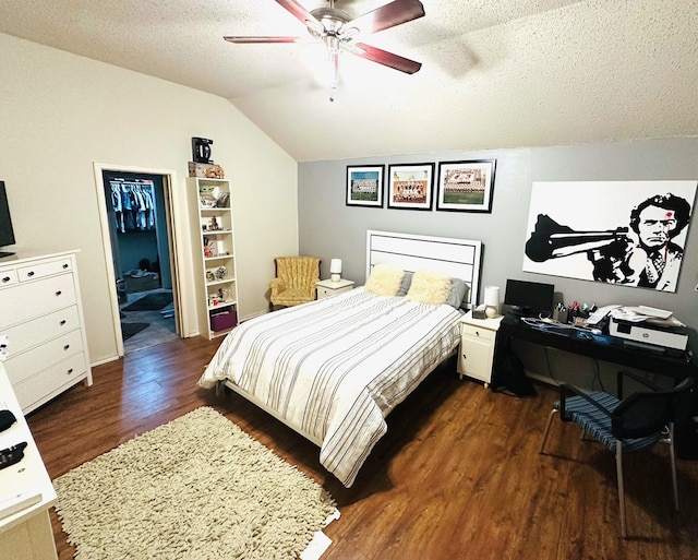 bedroom with dark wood-type flooring, ceiling fan, vaulted ceiling, and a textured ceiling