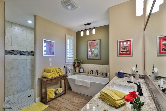 bathroom featuring vanity, shower with separate bathtub, hardwood / wood-style floors, and tile walls