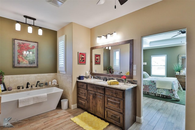 bathroom with vanity, hardwood / wood-style floors, a bathing tub, and ceiling fan