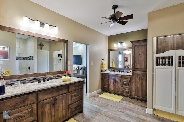 bathroom with ceiling fan, vanity, hardwood / wood-style floors, and a shower