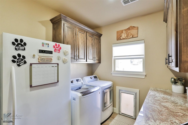 washroom with independent washer and dryer and cabinets