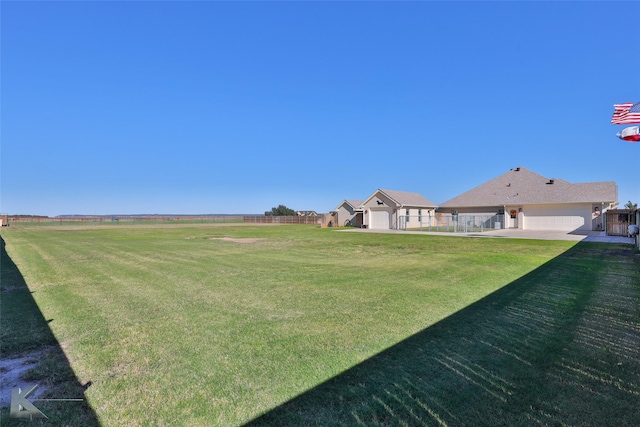 view of yard with a garage and a rural view