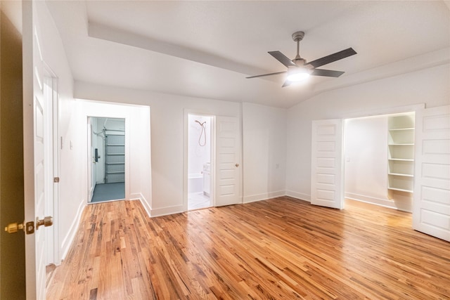 unfurnished bedroom featuring ensuite bath, ceiling fan, light hardwood / wood-style floors, a spacious closet, and a closet